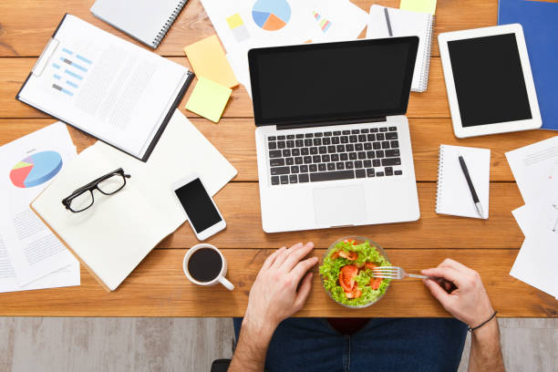 Person working at desk with healthy lunch nearby